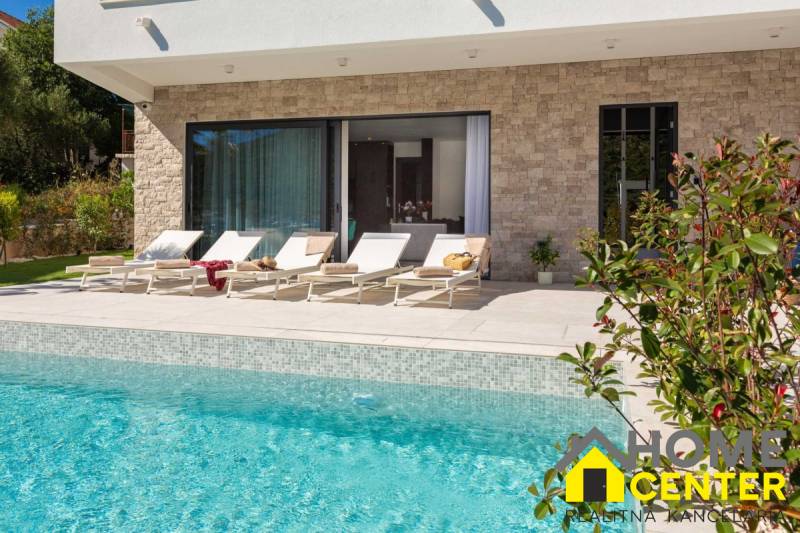 Exteriér vily v Bale s bazénem a lehátky na terase.