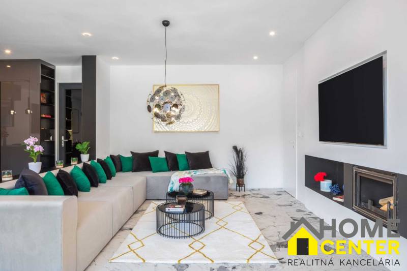 Obývací pokoj s pohodlnou sedačkou, krbem a dekoracemi ve vile.