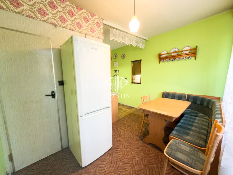 Jídelní kout se sedací soupravou a stolem ve 3-pokojovém bytě.