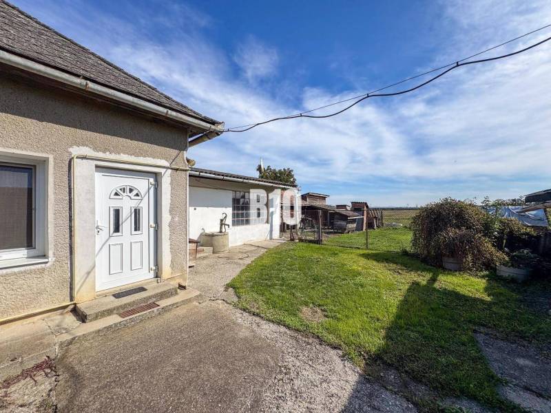 Rodinný dům v Ondrejovcích s dvorem, studnou a výhledem na otevřenou krajinu.