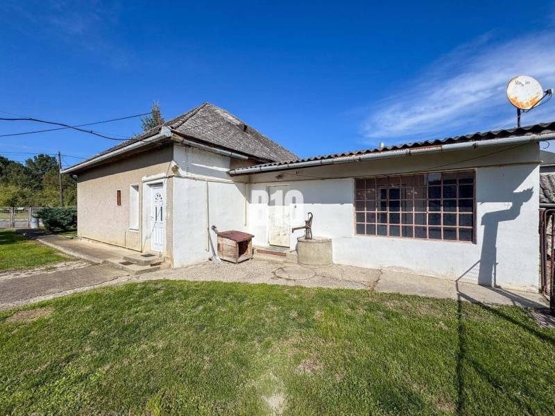 Rodinný dům v Ondřejovcích, starší stavba s dřevěnými okny a satelitem na střeše.