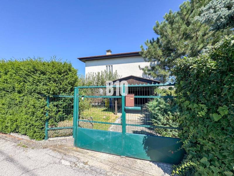 Rodinný dům na Kamenné ulici v Nitře se zahradní bránou a zelení.