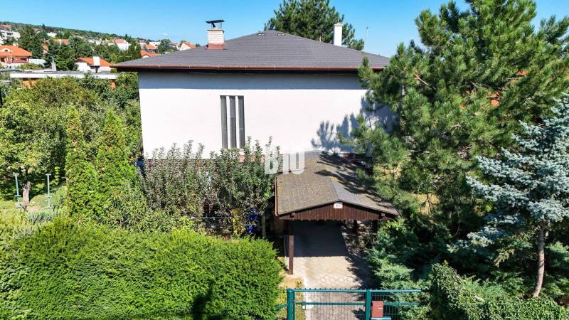 Rodinný dům na Kamennej ulici v Nitře obklopený zelení a stromy.