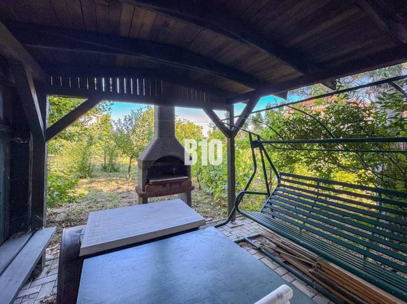 Zahrada v rodinném domě na Kamenné ulici v Nitře se zahradním krbem a houpačkou.