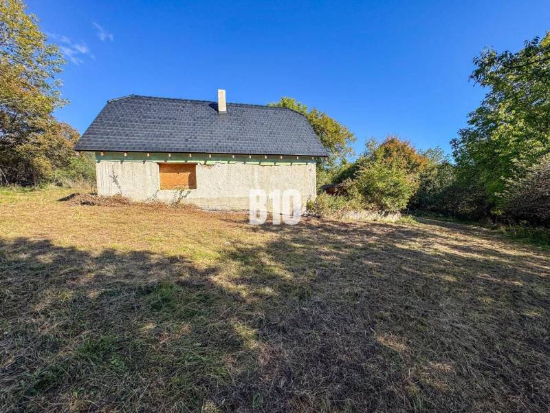 Chata v Lackově obklopená přírodou, zobrazená ve slunečném prostředí.