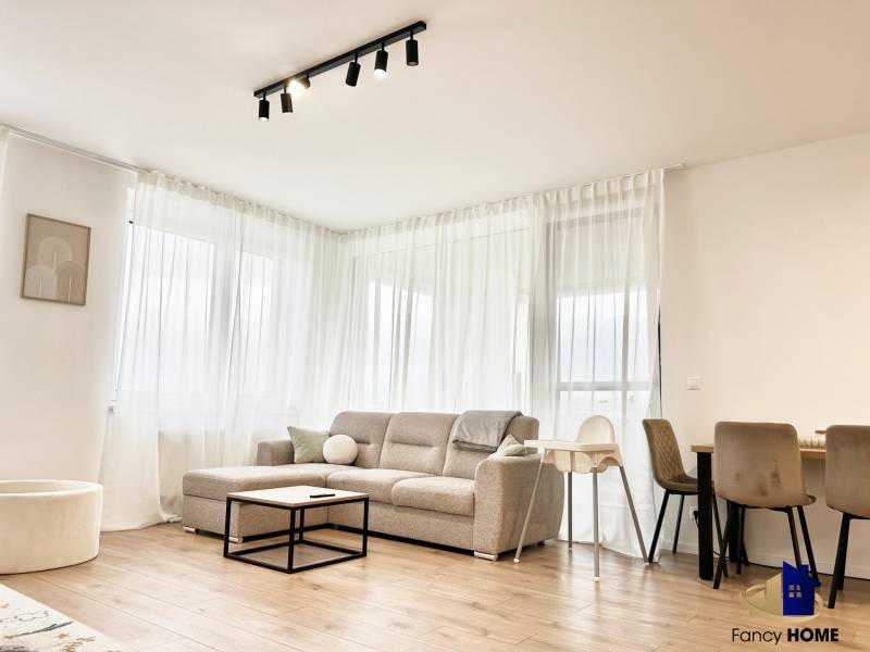 Obývací pokoj v 2-pokojovém bytě s pohovkou a podlahou s dřevěným dekorem.