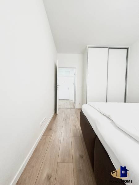 Pokoj v 2pokojovém bytě s podlahou s dřevěným dekorem a vestavěnou skříní.