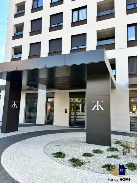 Vchod bytového domu na Karpatské ulici v Popradu se zahradní úpravou u 2-pokojových bytů.