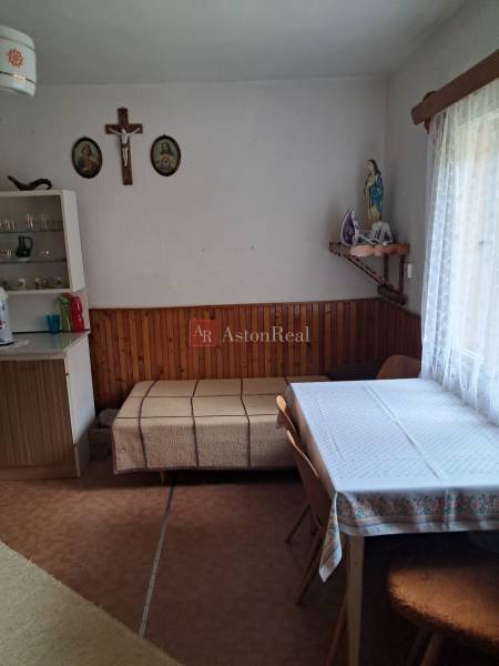 Jídelna v rodinném domě se stolem, židlemi a náboženskými dekoracemi na stěně.