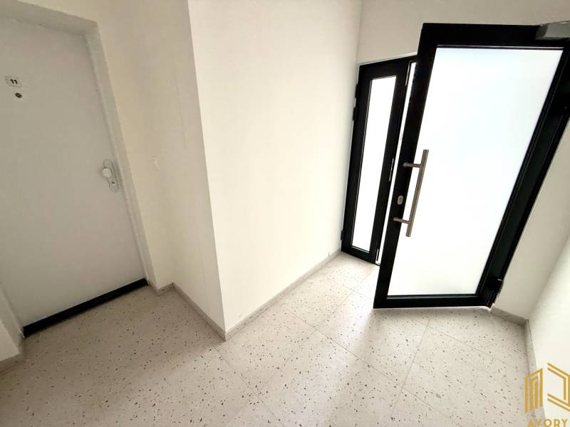 Vstupní chodba v 2-pokojovém bytě se skleněnými dveřmi.