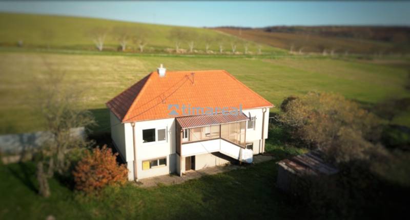 Rodinný dům v Dobré Vodě se šikmou střechou, obklopený zelení a loukami.