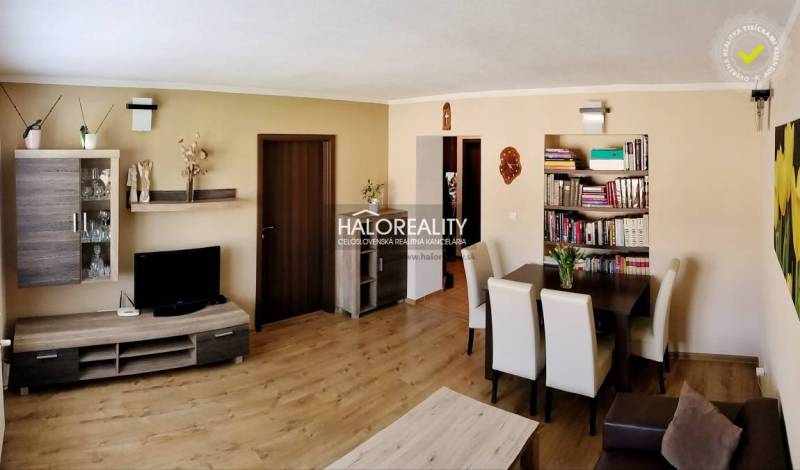 Obývací pokoj 3pokojového bytu s podlahou s dřevěným dekorem a jídelním koutem.