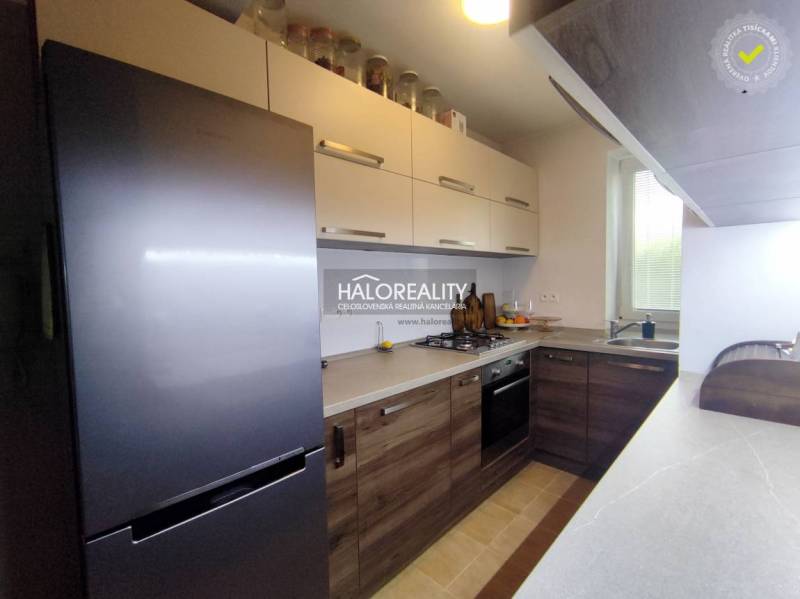 Kuchyně v 3-pokojovém bytě s podlahou s dřevěným dekorem a moderními spotřebiči.