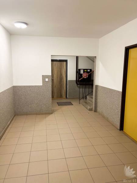 Vstupní hala s dlažbou a schody v obytném domě.