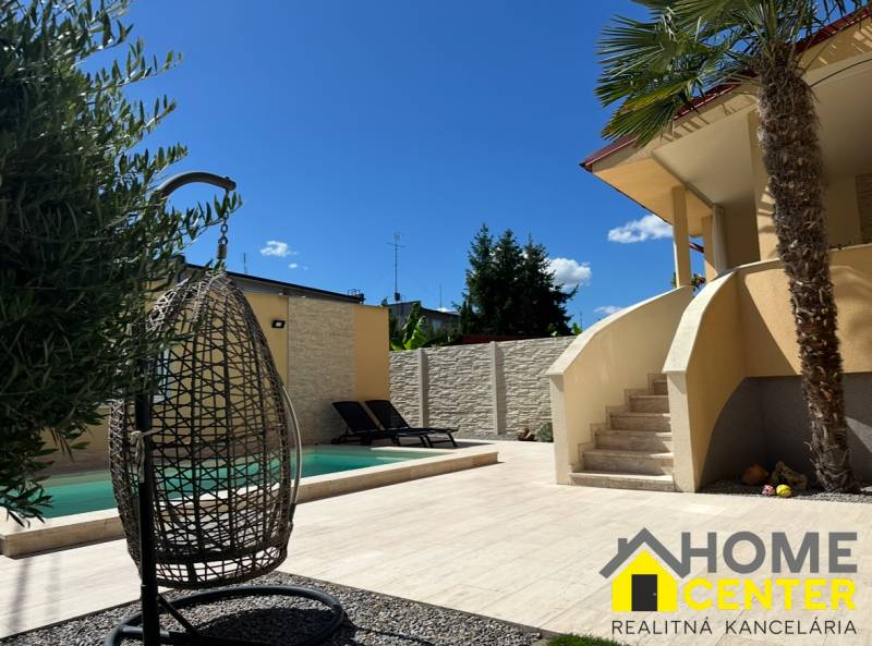 Rodinný dům v Komárně, exteriér se zahradou, bazénem a relaxačním koutkem.