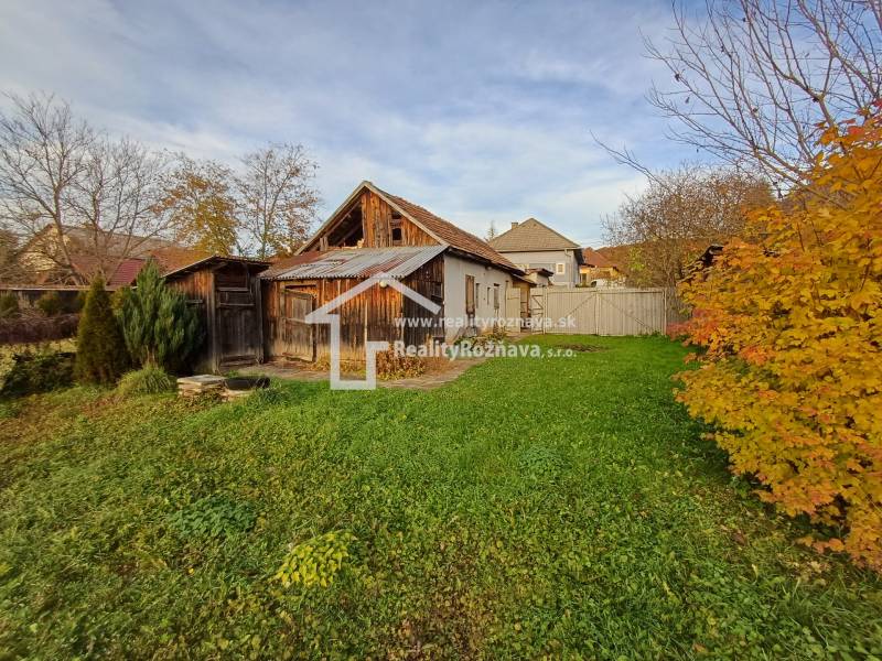 Rodinný dům v Dlouhé Vsi se zahradou, dřevěnými přístavbami a podzimní vegetací.