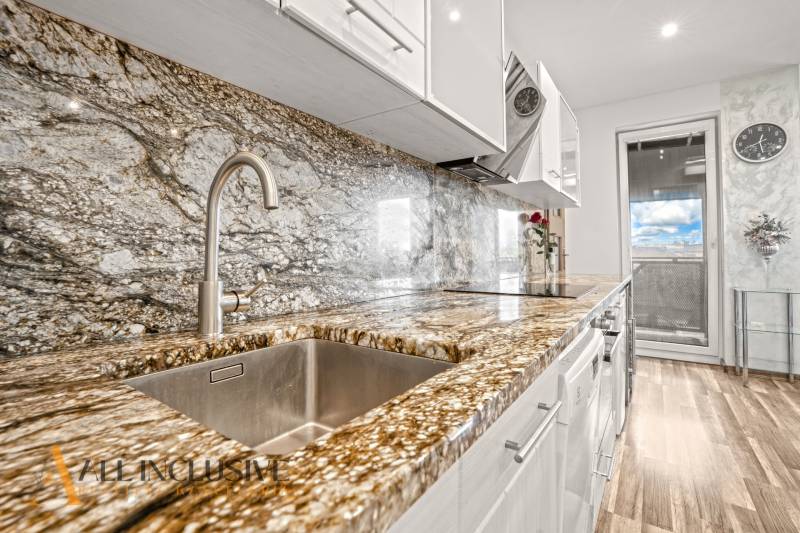 Kuchyně s kamennou pracovní deskou a podlahou s dřevěným dekorem v 3-pokojovém bytě.