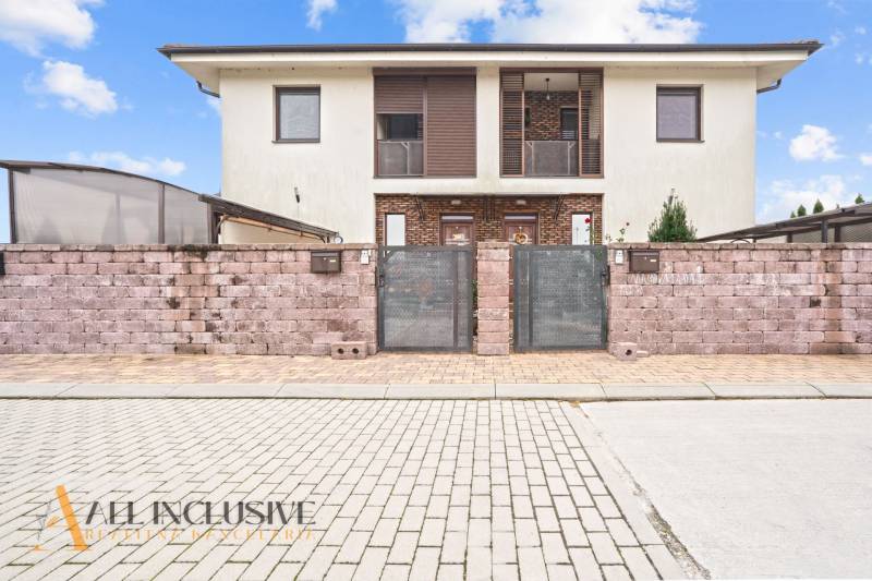 Dvojpodlažní dům s cihlovým plotem v Gabčíkovu, vhodný pro 3pokojový byt.