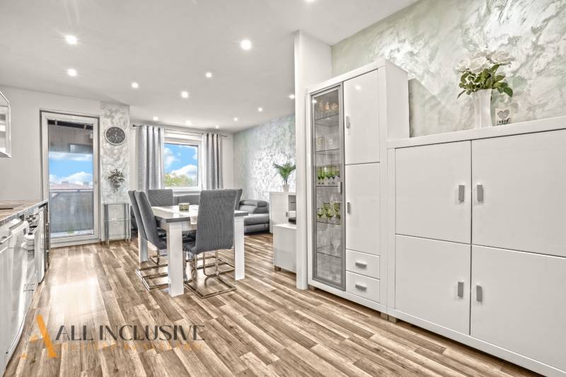 Světlý interiér 3-pokojového bytu s podlahou s dřevěným dekorem a bílým nábytkem.