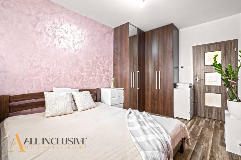 Ložnice s postelí, skříní a podlahou s dřevěným dekorem ve 3pokojovém bytě.