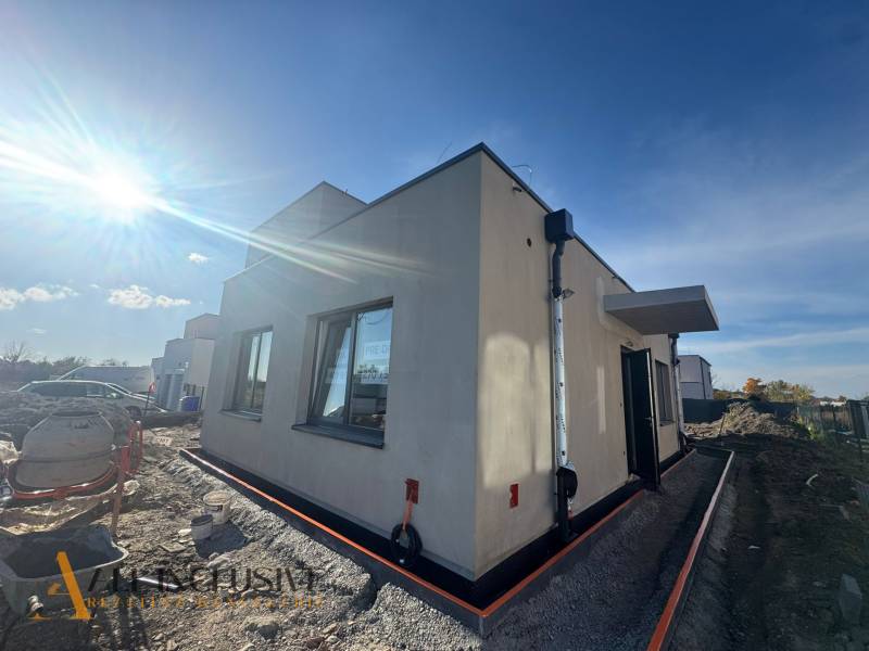 Exteriér rodinného domu v Hubicích během výstavby, slunečné počasí zesvětluje scénu.