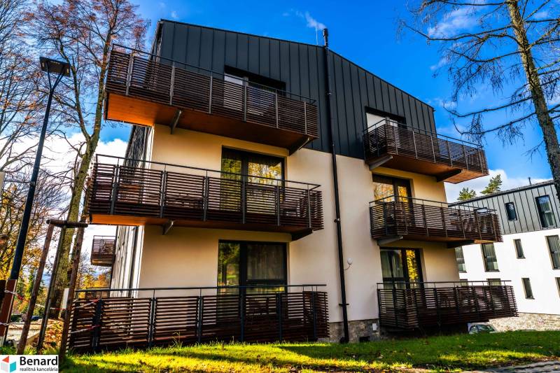 Bytový dům na ulici Lúčna v Štrbě s moderními balkony a okolní zelení.