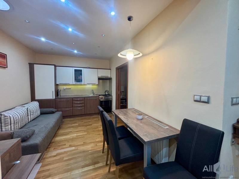 Kuchyňský kout s jídelním stolem v 1-pokojovém bytě s podlahou s dřevěným dekorem.