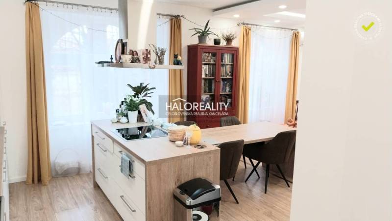 Moderní kuchyně ve 3pokojovém bytě s ostrůvkem a podlahou s dřevěným dekorem.