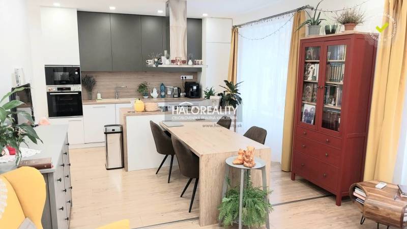 Interiér kuchyně v 3-pokojovém bytě s jídelním stolem a podlahou s dřevěným dekorem.