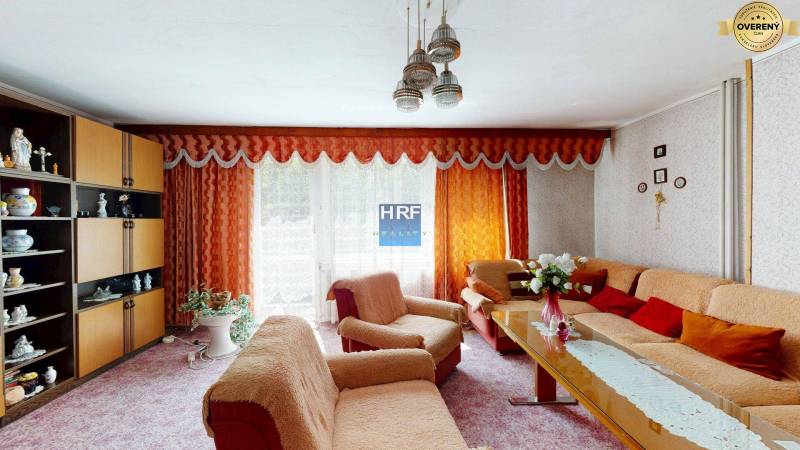 Obývací pokoj v rodinném domě s oranžovými závěsy a stylovým zařízením.