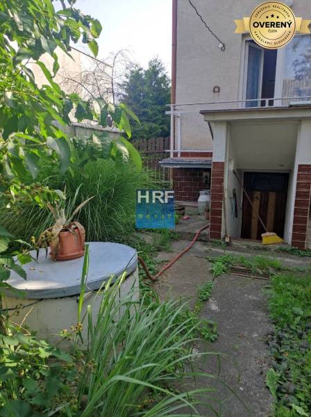 Zahrada rodinného domu na Viesce v Radošovicích s přístřeškem a bujnou vegetací.