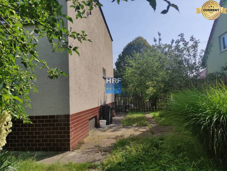 Zahrada u rodinného domu na Viesce v Radošovicích s chodníkem a plotem.