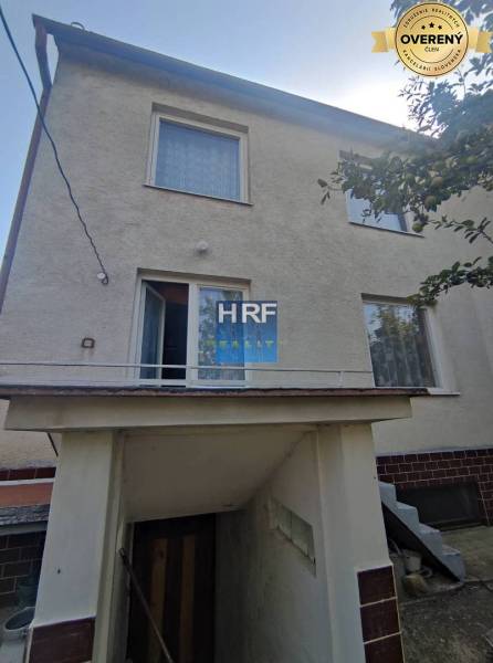 Rodinný dům v Radošovicích na Viesce s venkovním schodištěm a bílou fasádou.