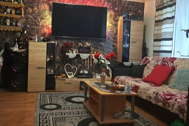 Obývací pokoj v 2-pokojovém bytě s dekorativními prvky a podlahou s dřevěným dekorem.