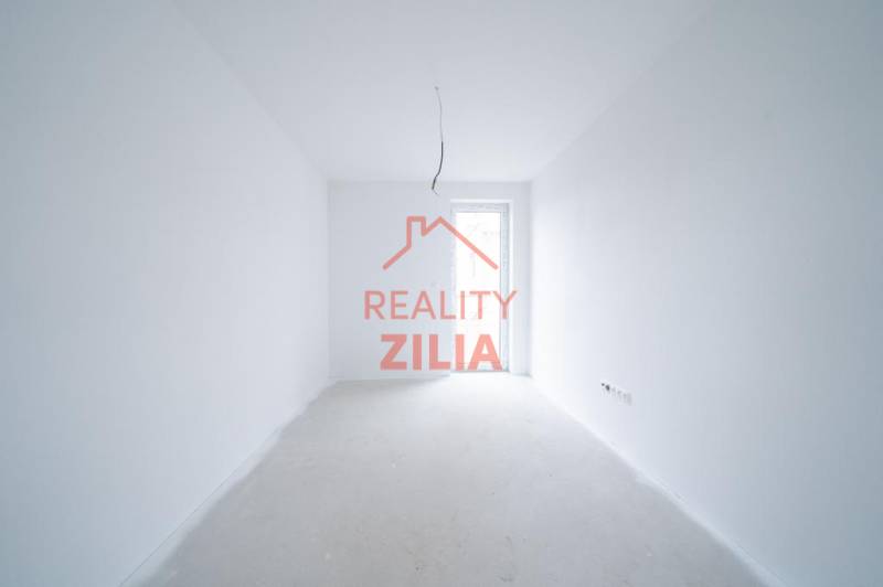 Prázdný interiér s bílými stěnami a otevřenými dveřmi v rodinném domě.