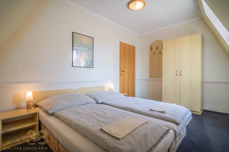 Dvoulůžkový pokoj s postelí, nočními stolky a skříní v hotelech a penzionech.