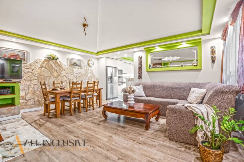 Obývací pokoj v rodinném domě s kamennou stěnou a podlahou s dřevěným dekorem.