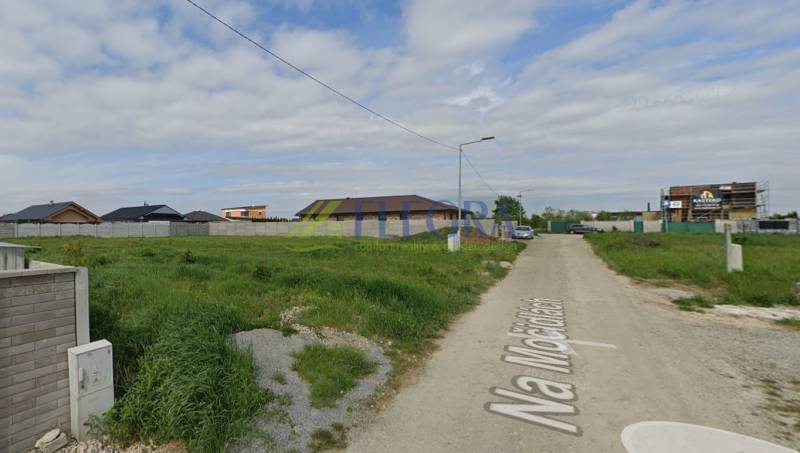 Pozemky - bydlení v Čani s výhledem na klidné předměstí a prázdnou cestu.