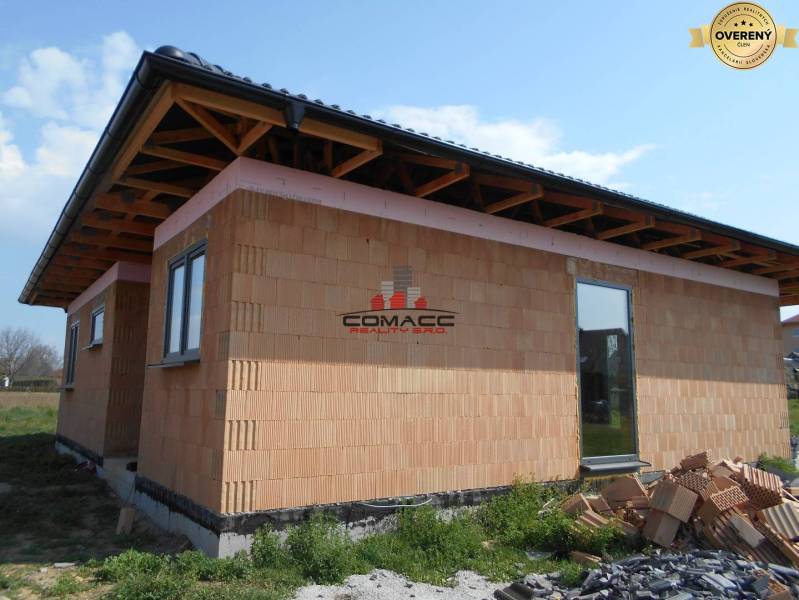 Rodinný dům v Novém Městě nad Váhom, zobrazuje rozestavěnou stavbu s cihlovou fasádou.