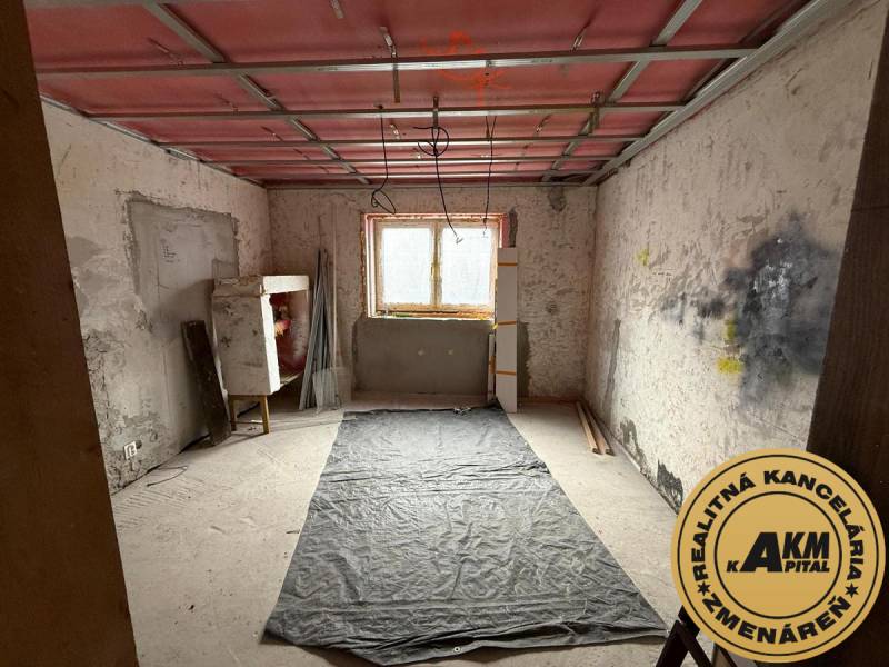 Místnost v rekonstrukci v rodinném domě s podlahou s dřevěným dekorem.