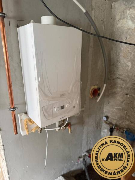 Kotelná rodinného domu ve Staré Kremničce s plynovým kotlem připevněným na stěnu.