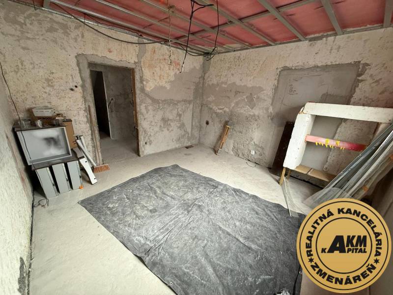 Interiér rodinného domu ve Staré Kremničce s odkrytými stěnami a podlahou.