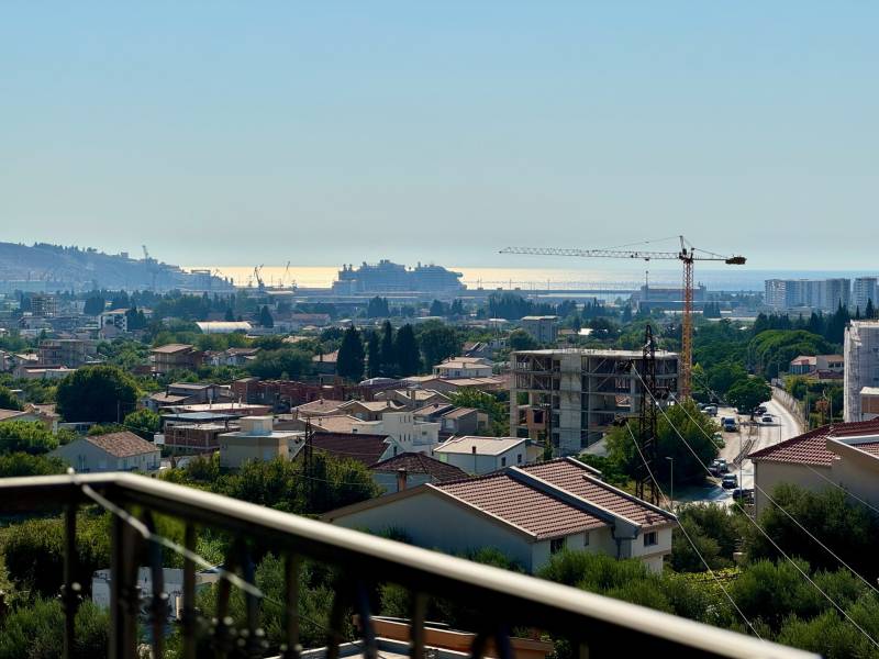 Pohled na město Bar s výhledem na moře a stavebními jeřáby.