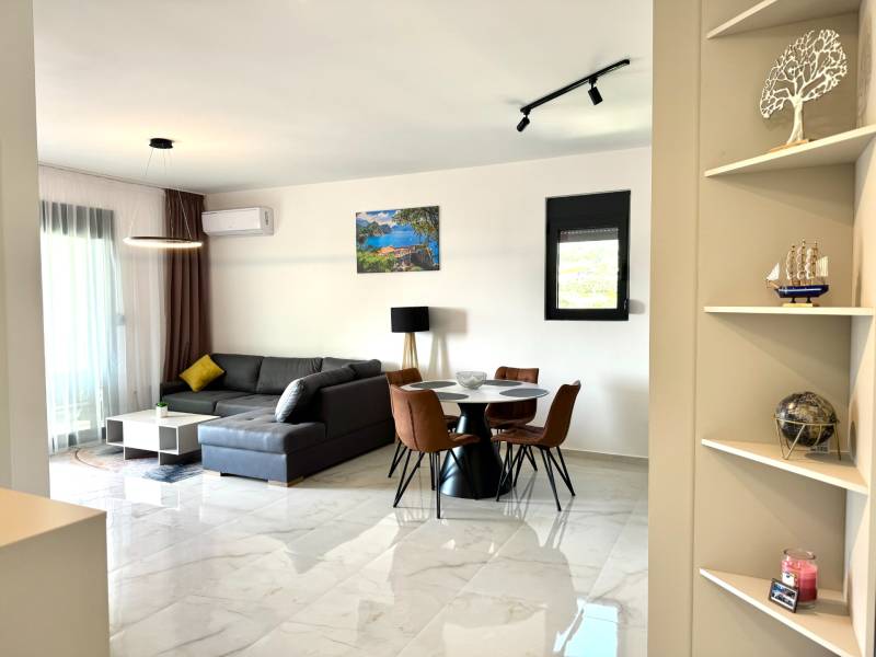 Obývací pokoj s pohodlnou rohovou pohovkou a jídelním stolem v 1-pokojovém bytě.