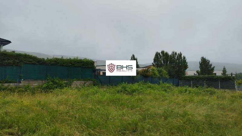 Pozemky na bydlení v Limbachu s travnatou plochou a živým plotem v pozadí.