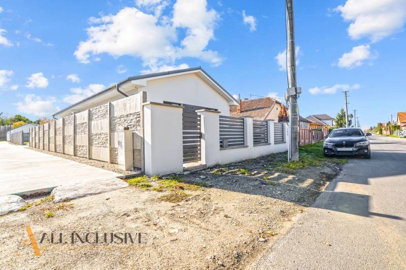 Rodinný dům v Orechovej Potôni s kamenným plotem a zaparkovaným autem na ulici.