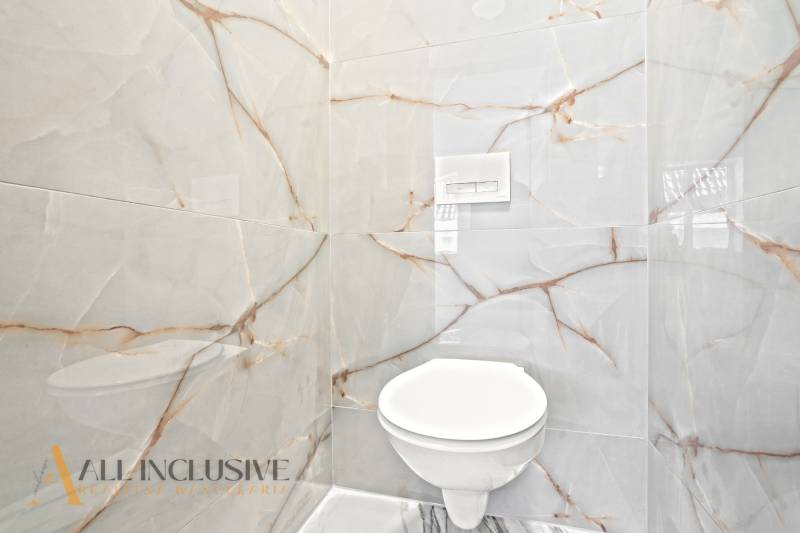 Koupelna v rodinném domě s luxusními obklady a zabudovaným záchodem.