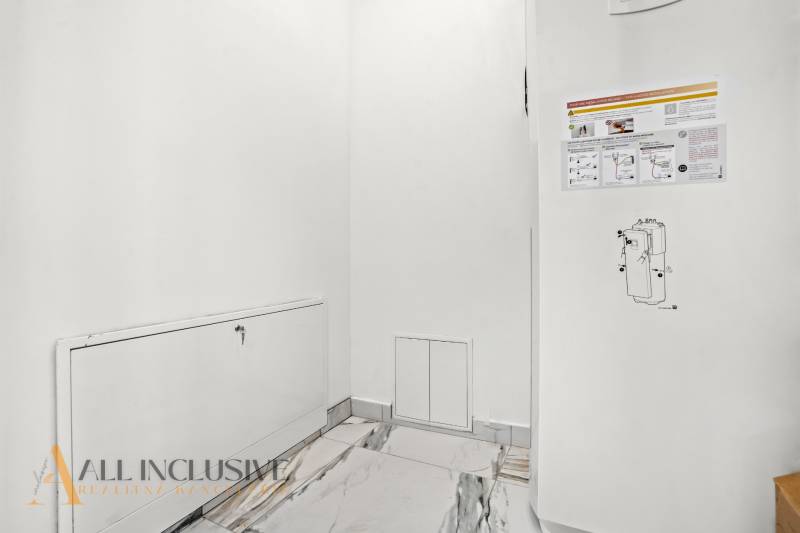 Bílá stěna s poklopem a informačními nálepkami v rodinném domě.