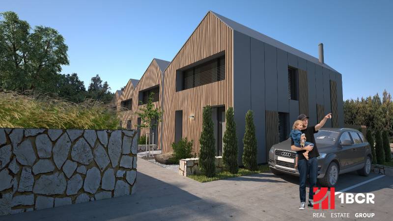 Rodinné domy v Turecké s dřevěným dekorem, kamenným plotem a zaparkovaným autem.