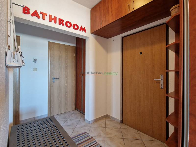 Vstupní chodba s dveřmi a věšákem v 3-pokojovém bytě, dlažba na podlaze.